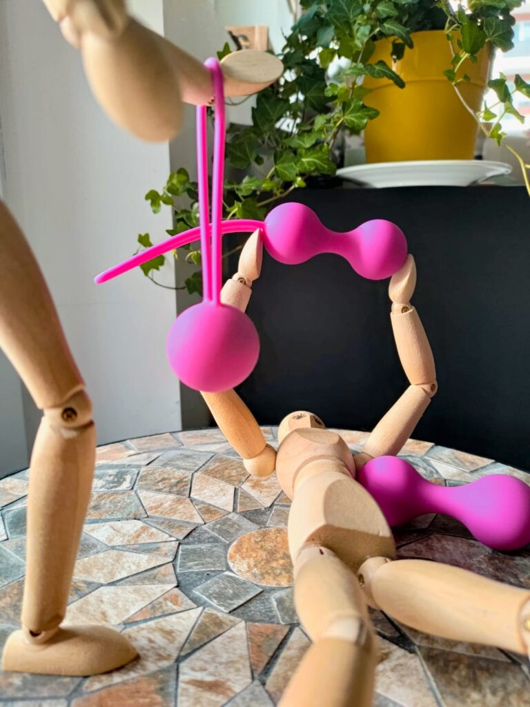 omuleti din lemn se antreneaza cu bile vaginale magenta pe post de haltere